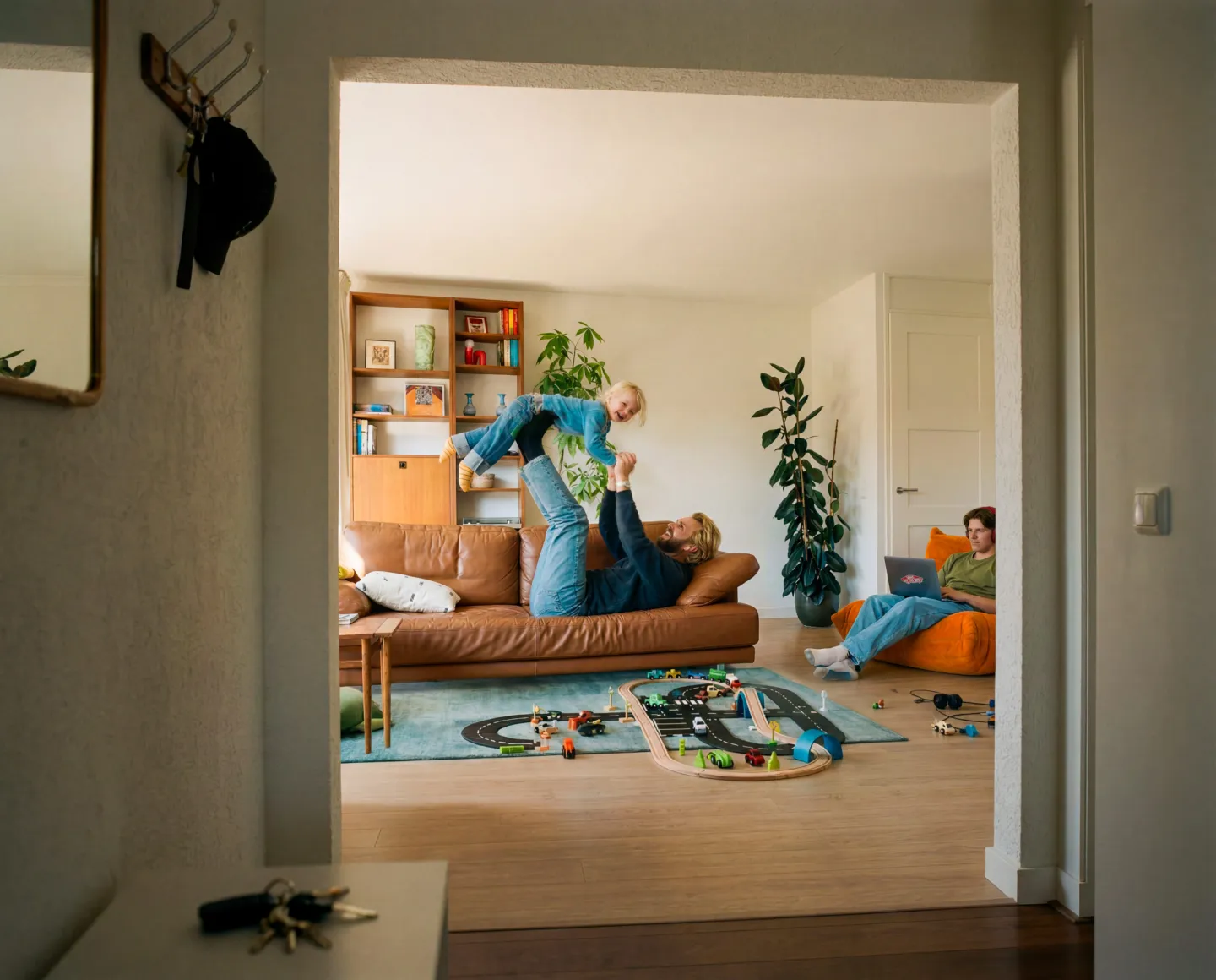 Gezin in de woonkamer, passend bij verzekeringen voor woning, spullen en financiële zekerheid.