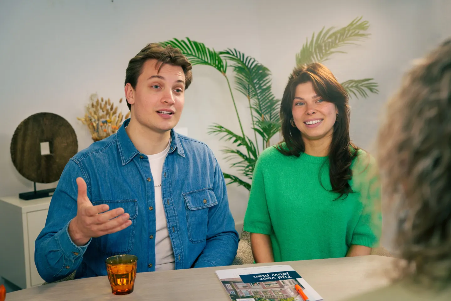 Jong stel bespreekt hun mogelijkheden voor een hypotheek met een adviseur van De Hypotheekshop Noord.