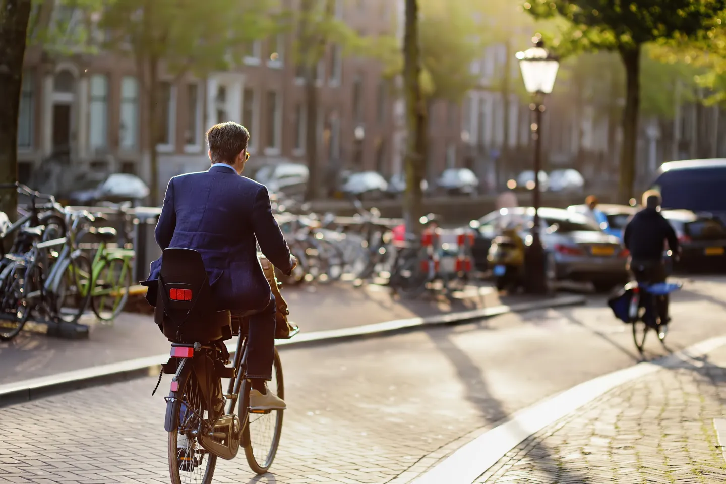 Expat cycling through a residential street in Amsterdam.