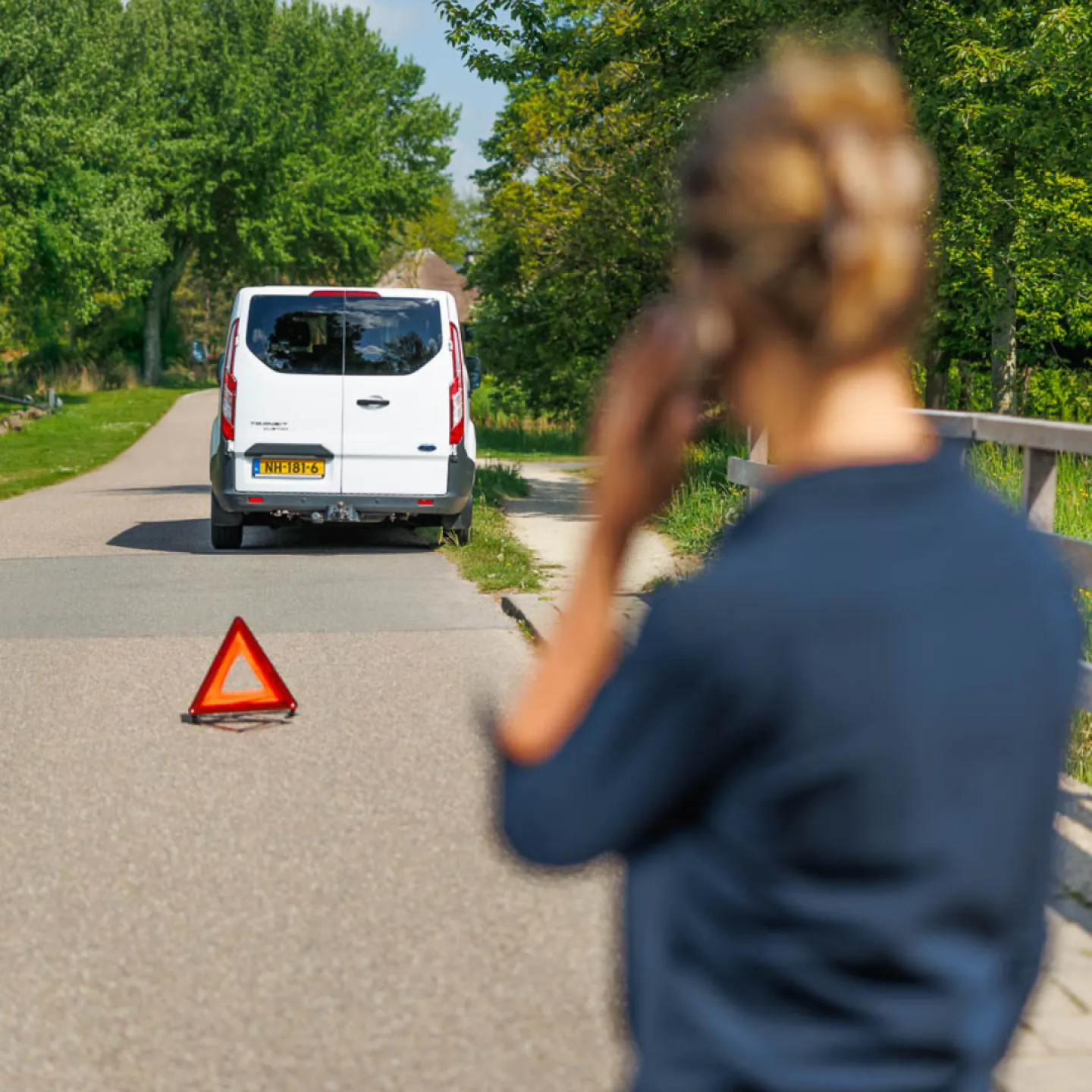 Vrouw belt hulpdienst bij autopech langs de weg
