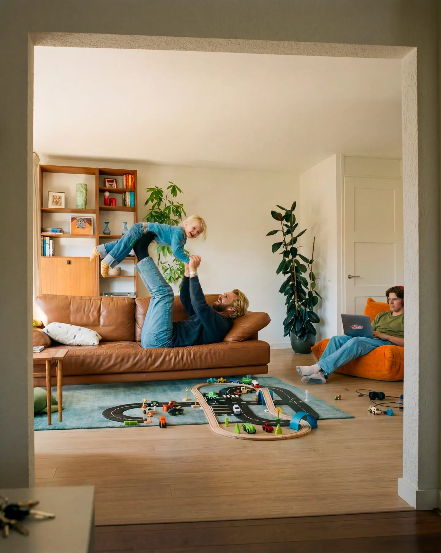 Gezin ontspant samen in de woonkamer van hun huis, passend bij verzekeringen voor je woning en gezin.
